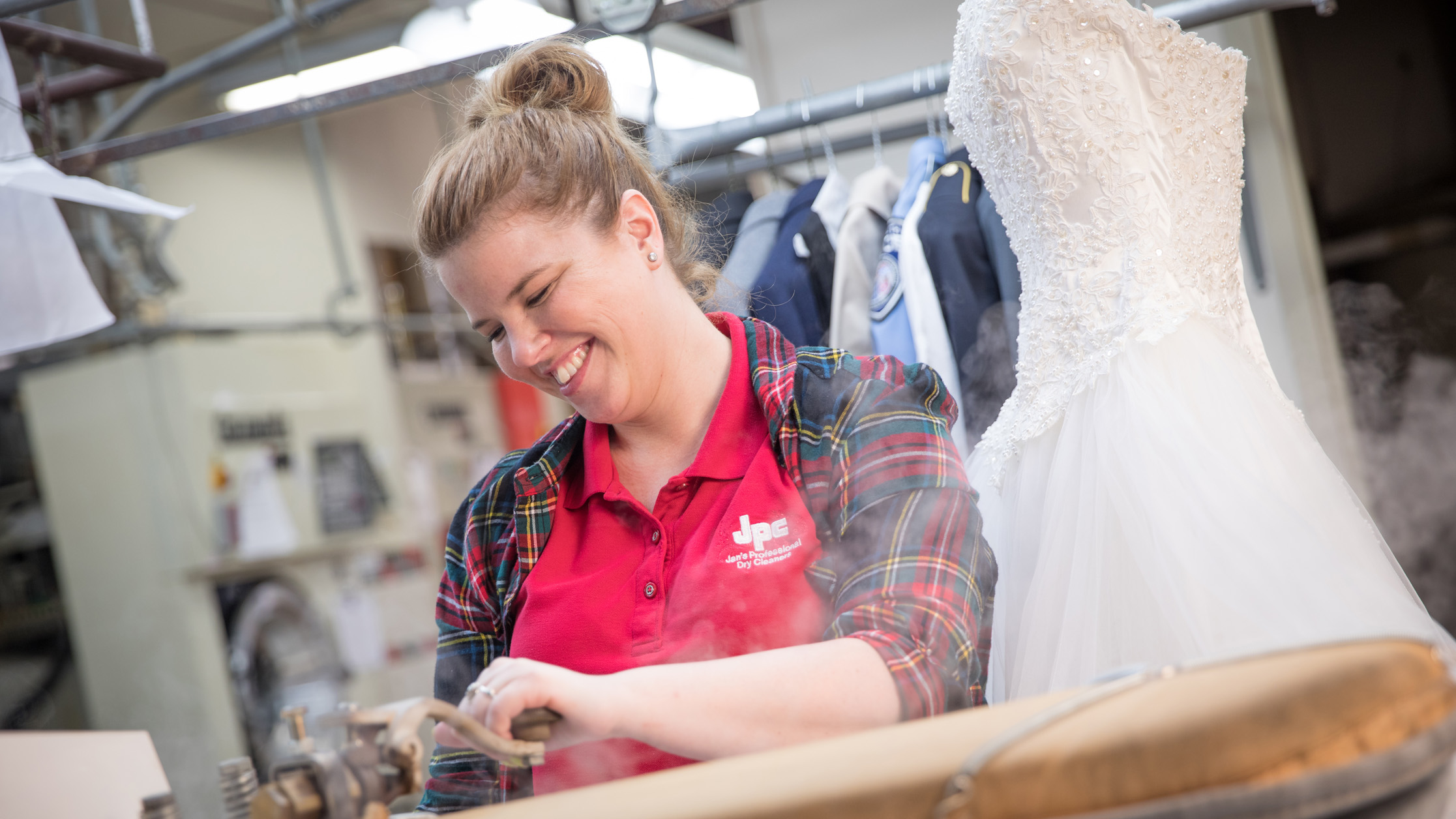 Ashley Dill steaming a dress at Jan's Professional Dry Cleaning