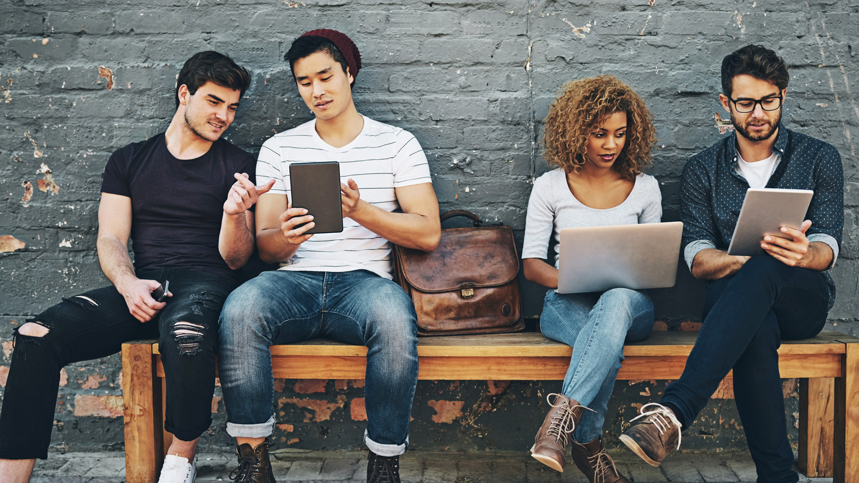 Group of young people working on electronic devices