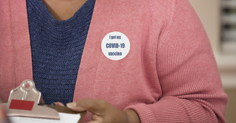 Woman with a "I've been vaccinated" sticker