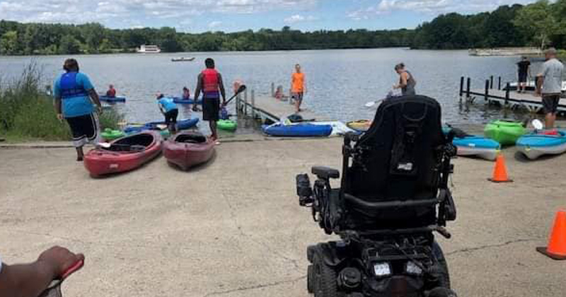 Wheelchair bound adults helped into kayaks