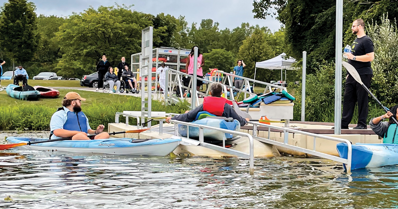 Wheelchair bound adults helped into kayaks
