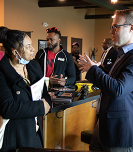 Chamber Executive Director, Andrew Younger, speaks to a member of the African American Advisory Committee inside King's Cigar Lounge