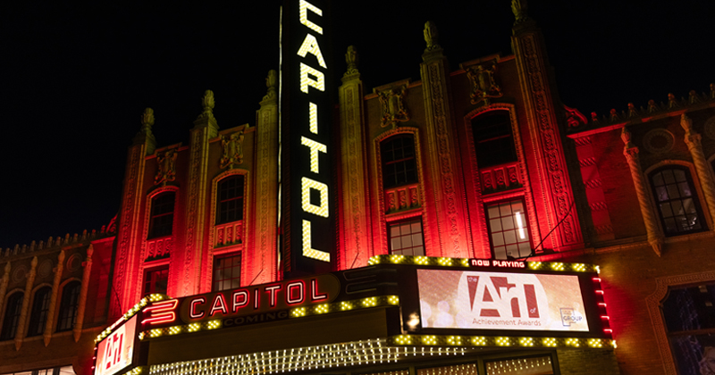 Marquee advertising the Art of Achievement Awards on the Capitol Theatre lit up at night.