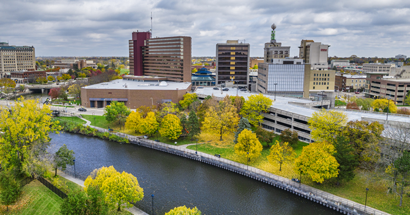 Aerial view of downtown Flint looking over the Flint river onto Saginaw Street showing Riverbank, Huntington Bank and the weather ball and other buildings.