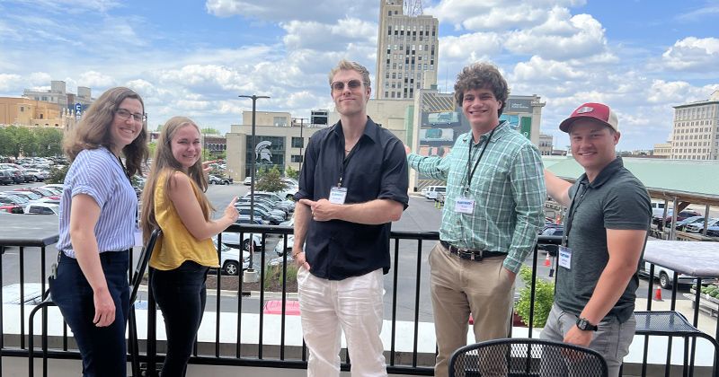 Five students in the Flintern program take a break for lunch on the balcony of the Flint Farmers' Market overlooking downtown Flint.
