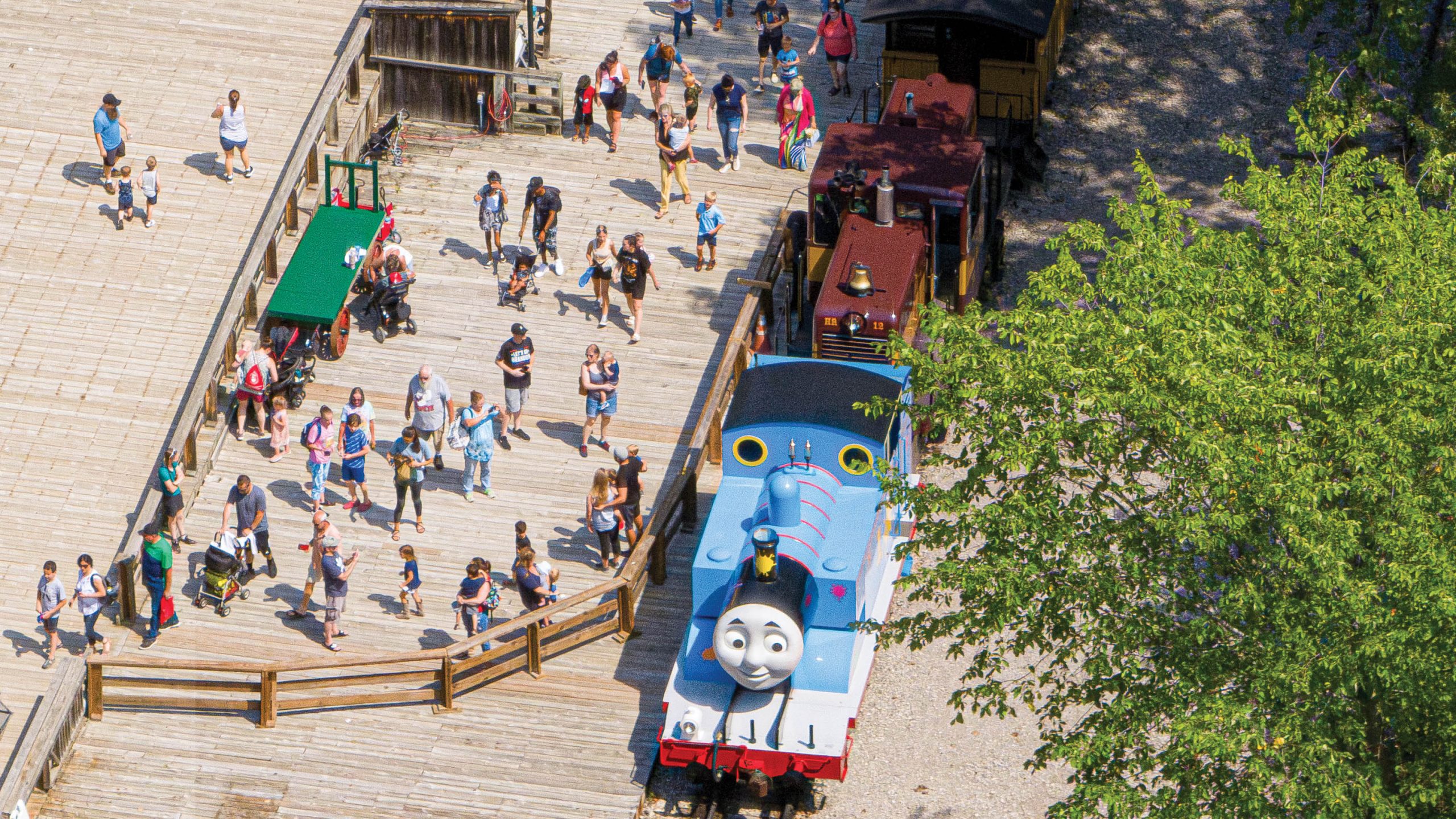Visitors to Crossroads Village disembark a coal-powered antique train that has cartoon Thomas the Train as the engine.