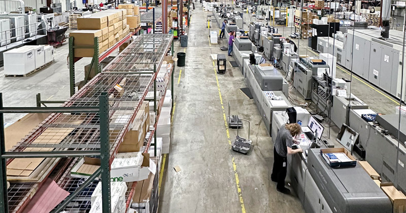 Inside a printer's warehouse where employees work the multiple aisles of printers.