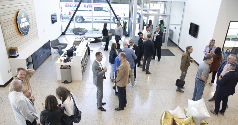 A group of business professionals mingle inside the lobby of a business
