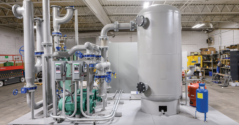 A cooling system consisting of large painted gray tanks and pipes with blue shut off handles.