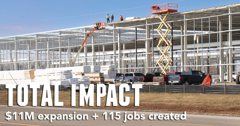 Construction workers work on the roof of a new steel-framed manufacturing facility
